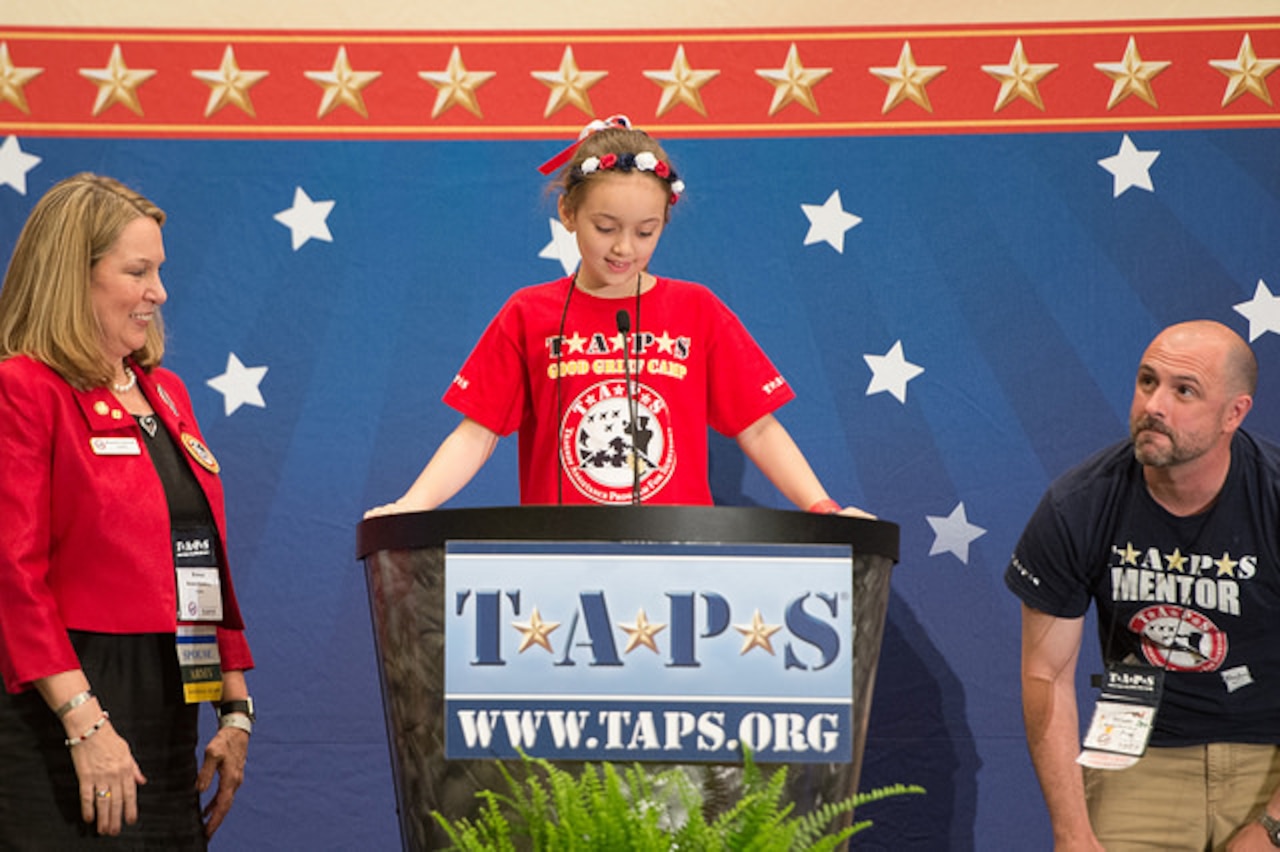 Lizzie Yaggy, 8, of New Orleans, supported by Bonnie Carroll, founder and president of Tragedy Assistance Program for Survivors, and a mentor, introduces Army Gen. Martin E. Dempsey during the 21st annual TAPS National Military Survivor Seminar and Good Grief Camp for Young Survivors in Crystal City, Va., May 22, 2015. DoD photo by Navy Petty Officer 1st Class Daniel Hinton