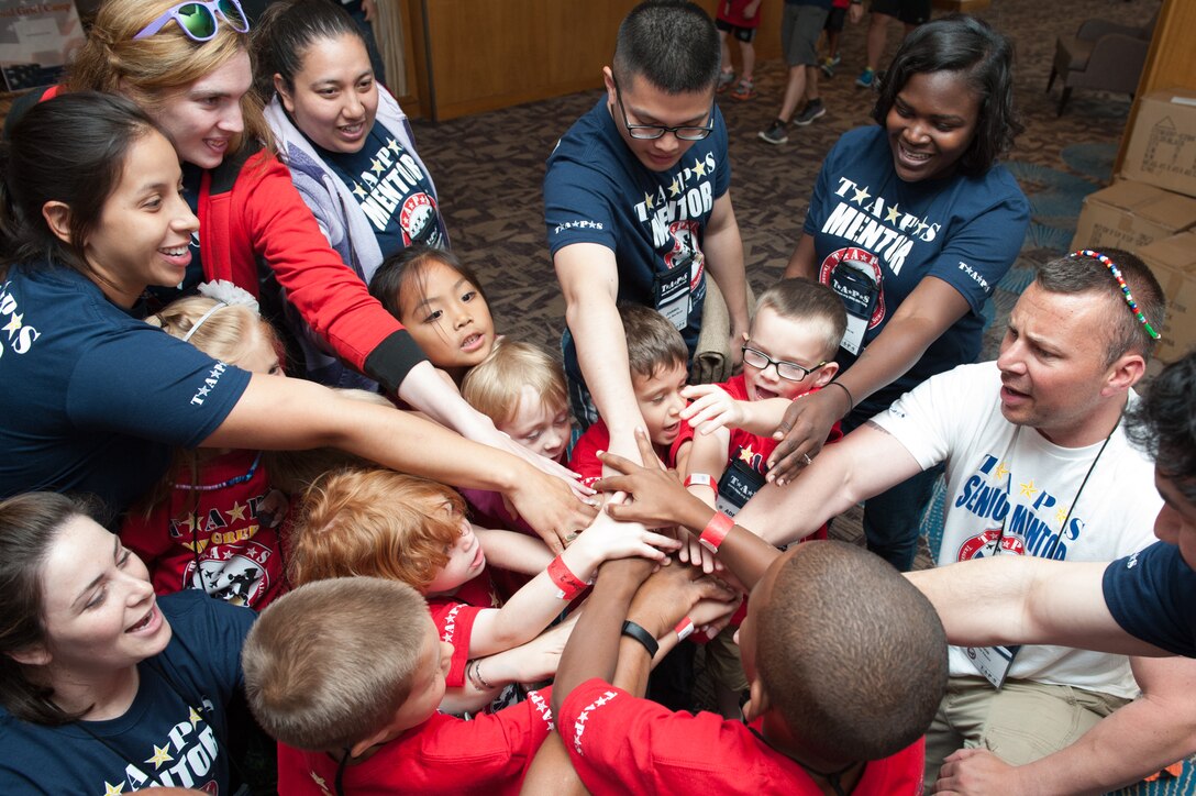Children and their mentors cheer during the 21st annual TAPS National Military Survivor Seminar and Good Grief Camp for Young Survivors in Arlington, Va., May 22, 2015.