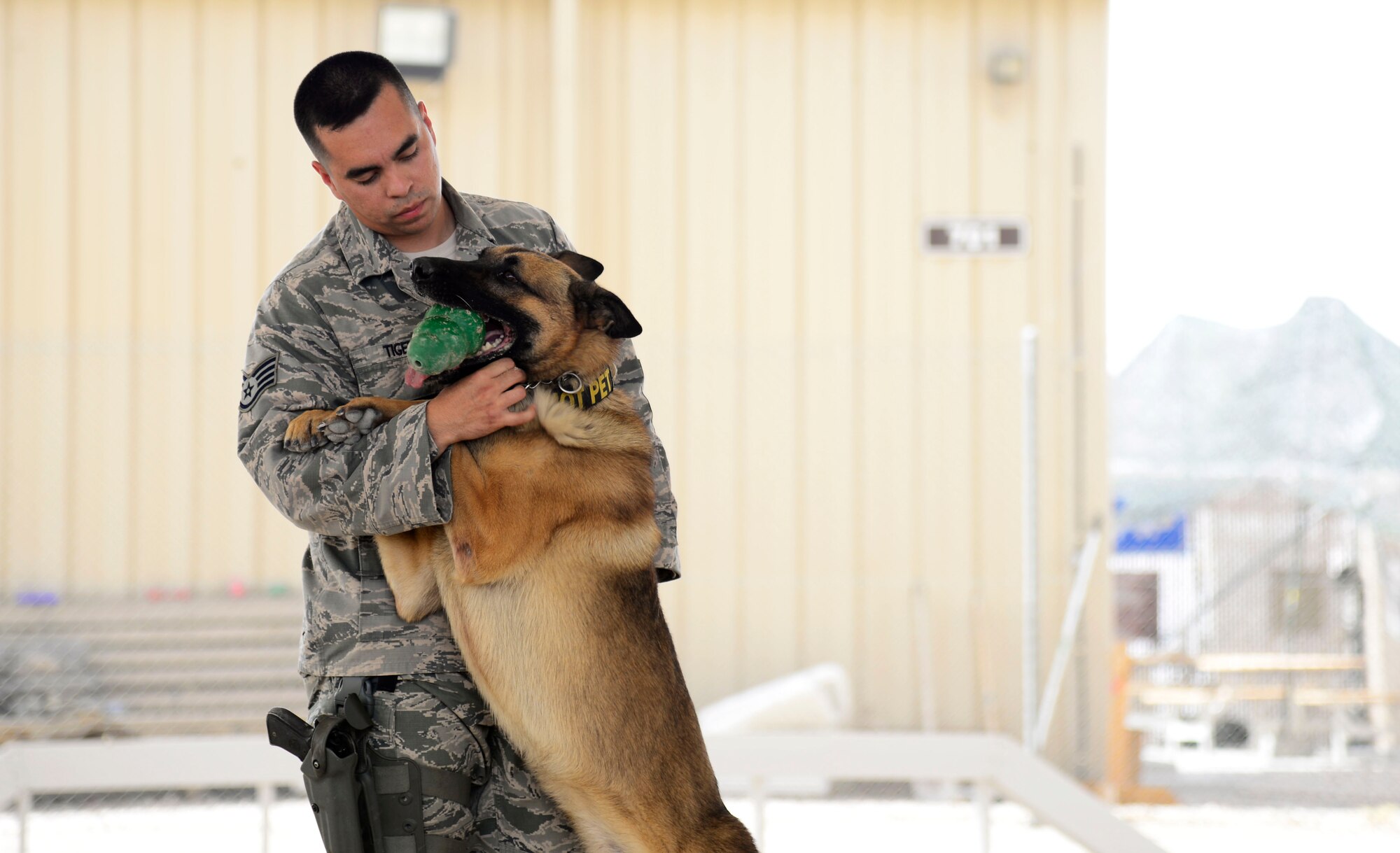 U.S. Air Force Staff Sgt. Devin Tiger, a 386th Expeditionary Security Forces Squadron Military Working Dog handler, hugs Nido, MWD, at an undisclosed location in Southwest Asia, May 21, 2015. Tiger observes Memorial Day every day, walking in the footsteps of a fallen MWD, Tech. Sgt. Jason Norton. (U.S. Air Force photo by Senior Airman Racheal E. Watson/Released)