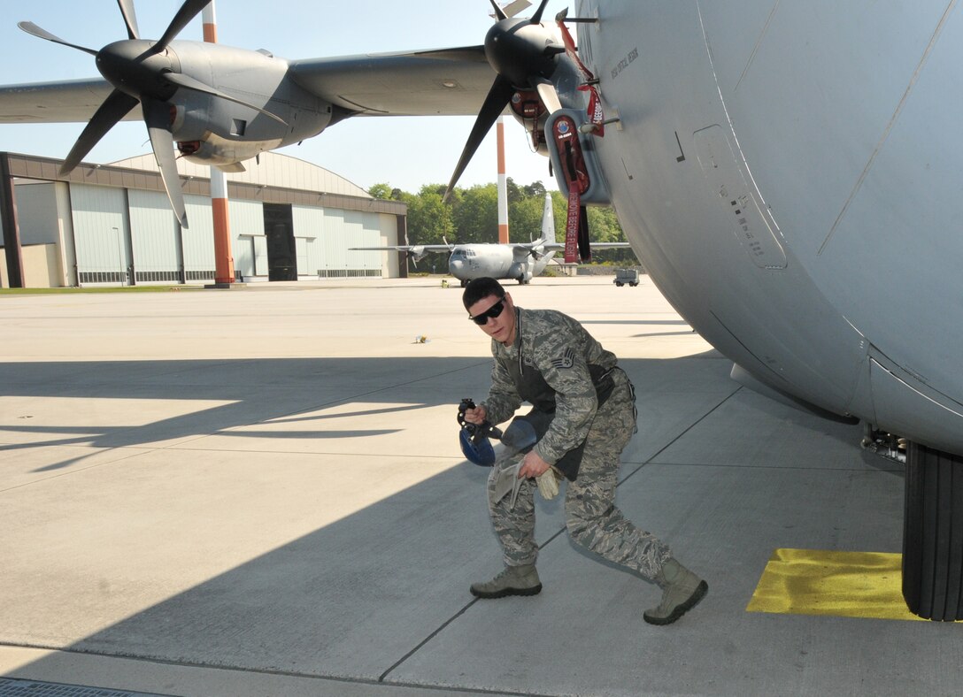The non-commissioned officer in charge of equipment, 104th Explosive Ordnance Flight (EOD), 104th Fighter Wing, Barnes Air National Guard Base, Westfield, Mass., walks around the C-130 aircraft prior to “Safeing” it, May 13, 2015, Ramstein, Air Base Germany. He is an emergency responder who will be qualified on “Safeing” the C-130 aircraft, making him more valuable to the 104th Fighter Wing and New England area. (U.S. Air National Guard photo by Tech. Sgt. Melanie J. Casineau/Released)