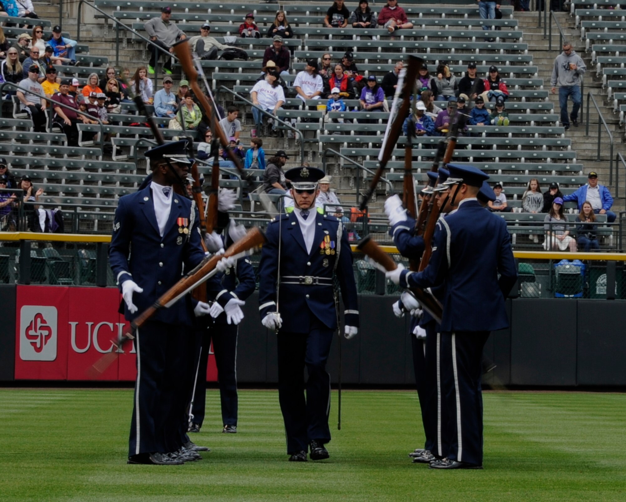 Capt. Cahn Wadhams, U.S. Air Force Honor Guard Ceremonial Flight commander, walks through spinning M-1 Garand rifles during a performance at Coors Field in Denver, Colo., May 24, 2015. The Drill Team promotes the Air Force mission by showcasing drill performances at public and military venues to recruit, retain and inspire Airmen. (U.S. Air Force photo by Senior Airman Preston Webb/RELEASED)