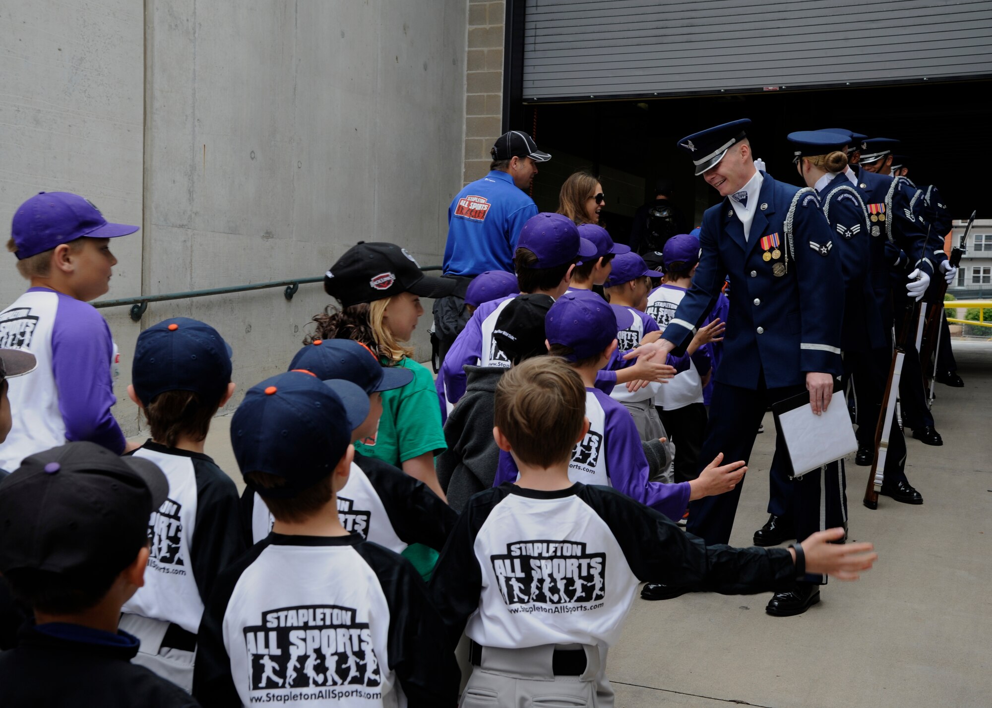 Members of the United States Air Force Honor Guard Drill Team high-five local community members at Coors Field in Denver, Colo., May 24, 2015. The Drill Team promotes the Air Force mission by showcasing drill performances at public and military venues to recruit, retain and inspire Airmen. (U.S. Air Force photo by Senior Airman Preston Webb/RELEASED)