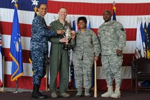 U.S. Navy Adm. Cecil D. Haney (left), U.S. Strategic Command commander, and U.S. Army Command Sgt. Maj. Patrick Z. Alston (right), USSTRATCOM senior enlisted leader, present the 2014 Omaha Trophy, intercontinental ballistic missile wing category, to U.S. Air Force Col. Michael Lutton (center left), 91st Missile Wing commander, and U.S. Air Force Chief Master Sgt. Felica Noil, 91st Missile Wing command chief, on Minot Air Force Base, N.D., May 20, 2015. The unit is one of four Omaha Trophy-winning units for 2014 and joins winners in the strategic aircraft operations wing, ballistic missile submarine and global operations (space/cyberspace) unit categories. Those receiving the awards represent units throughout USSTRATCOM which are critical to fulfilling the combatant command's primary mission: to detect, deter and prevent strategic attacks against the United States and its allies. USSTRATCOM is one of nine unified commands under the Department of Defense and is responsible for strategic deterrence; space operations; cyberspace operations; joint electronic warfare; global strike; missile defense; intelligence, surveillance and reconnaissance; combating weapons of mass destruction; and analysis and targeting. (U.S. Air Force photo/Senior Airman Kristoffer Kaubisch)