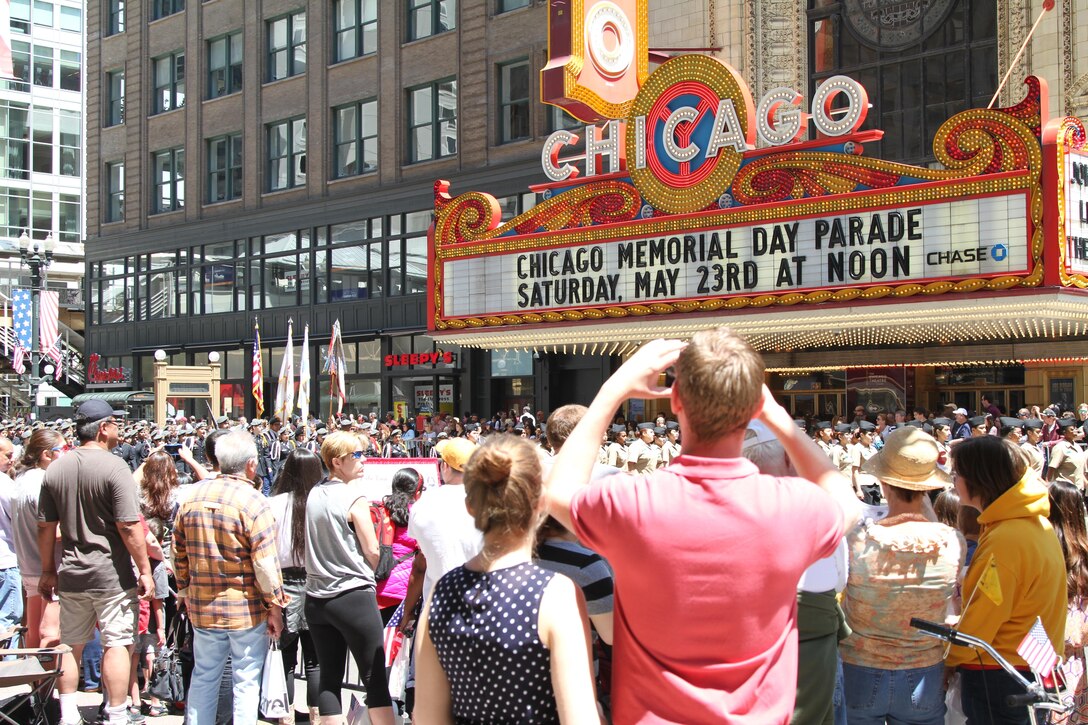 Spectators at the 2015 Chicago Memorial Day parade take photos as one of the many floats, marching bands and JROTC units pass by the Chicago Theater May 23, 2015. The annual parade is considered one of the largest in the nation and attracts thousands of visitors each year to remember those who have paid the ultimate sacrifice for American freedom.