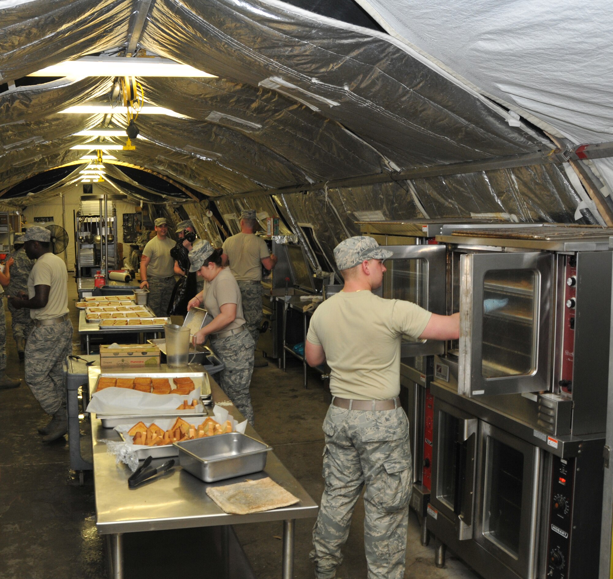 Members from the 104th Services Flight, Barnes Air National Guard Base, Westfield, Mass., prepare dinner in a busy kitchen May 13, 2015, during Exercise Silver Flag, Ramstein Air Base, Germany. Silver Flag is a U.S. Air Force training course designed to educate airman with valuable skills allowing them to know how to deploy using real-world equipment in real-world scenarios. (U.S. Air National Guard photo by Tech. Sgt. Melanie J. Casineau/Released)