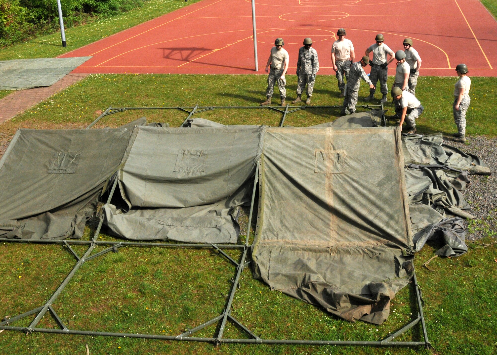 Members of the 104th Services Flight work together to set up a temporary tent May 11, 2015, Ramstein Air Base, Germany, in preparation for exercise Silver Flag. Silver Flag is an eight-day training course designed to prepare Airmen for any bare-base deployment.(U.S. Air National Guard photo by 2nd Lt. Bonnie Harper)