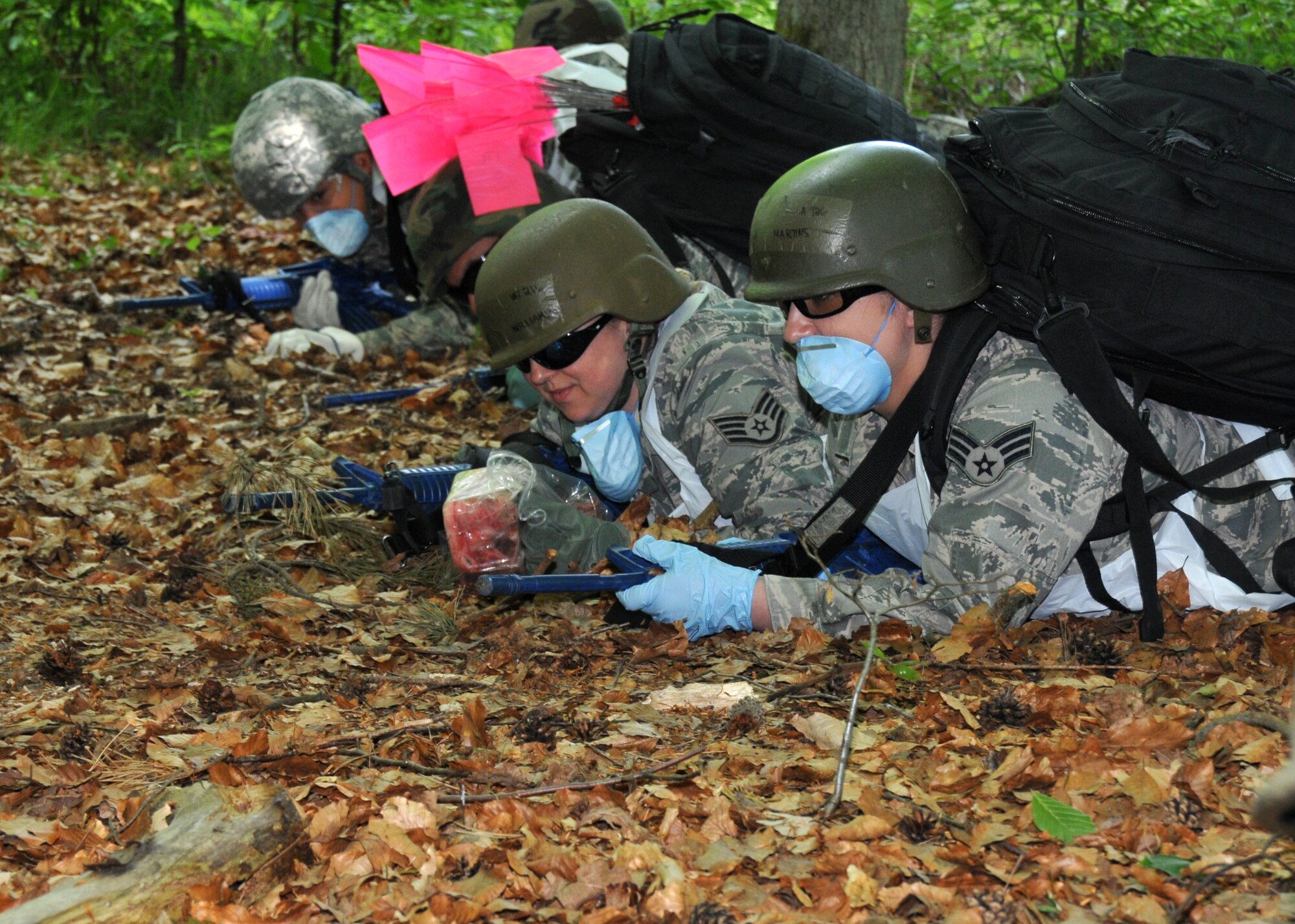 Airmen from the 104th Services Flight, Barnes Air National Guard Base, Westfield, Mass., take cover from simulated enemy fire during an expedited search and recovery exercise May 13, 2015, during Exercise Silver Flag. Silver Flag is an eight-day training exercise designed to prepare Airmen for bare-base deployments. (U.S. Air National Guard photo by 2nd Lt. Bonnie Harper/Released)