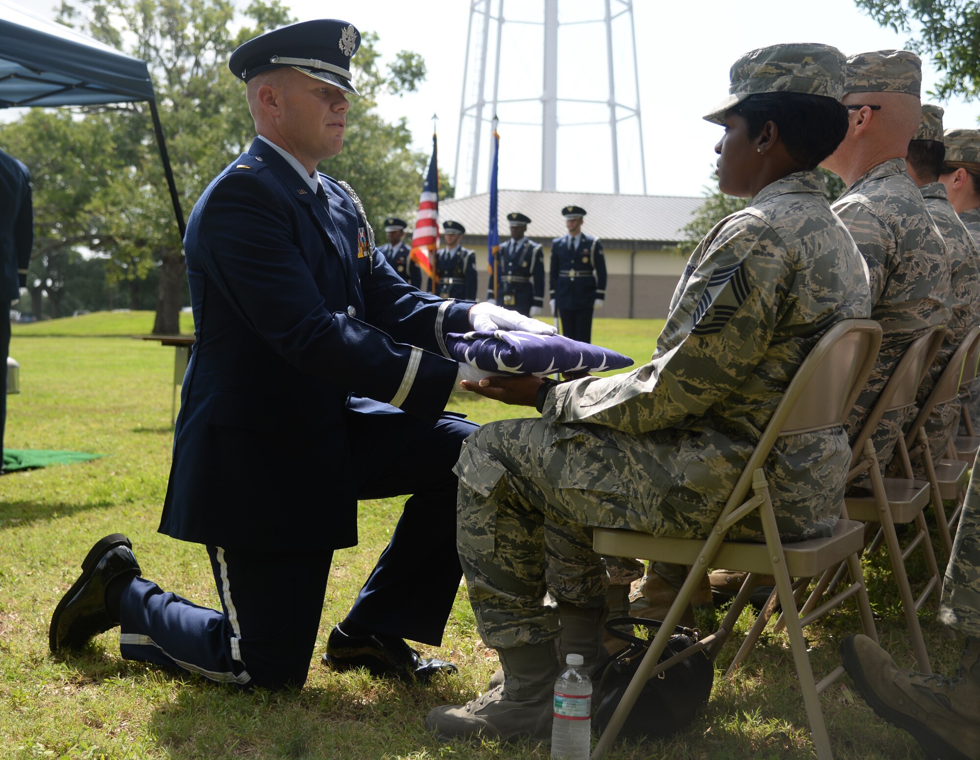 Air Force 2nd Lt. John Newland, 159th Fighter Wing Louisiana Air National Guard Base Honor Guard member, presents the U.S. flag to Chief Master Sgt. Sachiko Cleveland, 81st Force Support Squadron superintendent, during a mock active duty funeral, May 20, 2015, Keesler Air Force Base, Miss. Three members of the Air Force Honor Guard Mobile Training Team conducted a 7-day training course for members of the Keesler, Columbus AFB, Maxwell AFB, Ala., and the 159th FW Louisiana Air National Guard base honor guards. During the training participants were trained on firing party, flag presentations and pallbearer duties. (U.S. Air Force photo by Senior Airman Holly Mansfield)