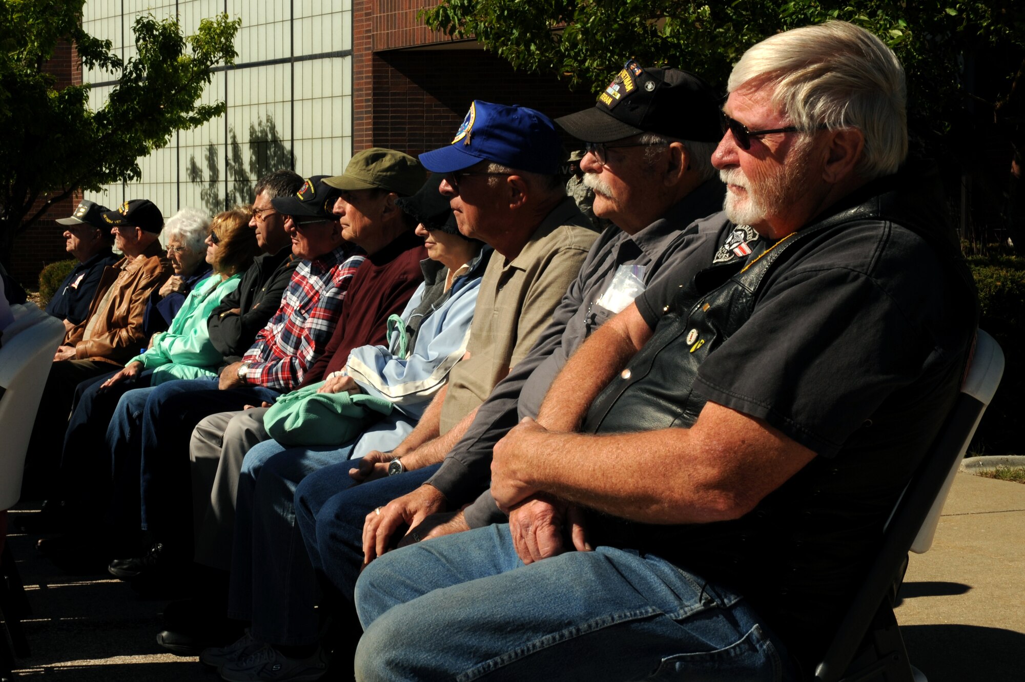 Vietnam and Korean War veterans and their families listen to a speech at the Memorial Day retreat ceremony at Ellsworth Air Force Base, S.D., May 21, 2015. Ellsworth hosted a Memorial Day event, inviting local World War II, Vietnam and Korean War veterans and their family members to tour the base, view a B-1 bomber and munitions display, and attend a retreat ceremony at the 28th Bomb Wing headquarters building. (U.S. Air Force photo by Senior Airman Hailey R. Staker/Released) 
