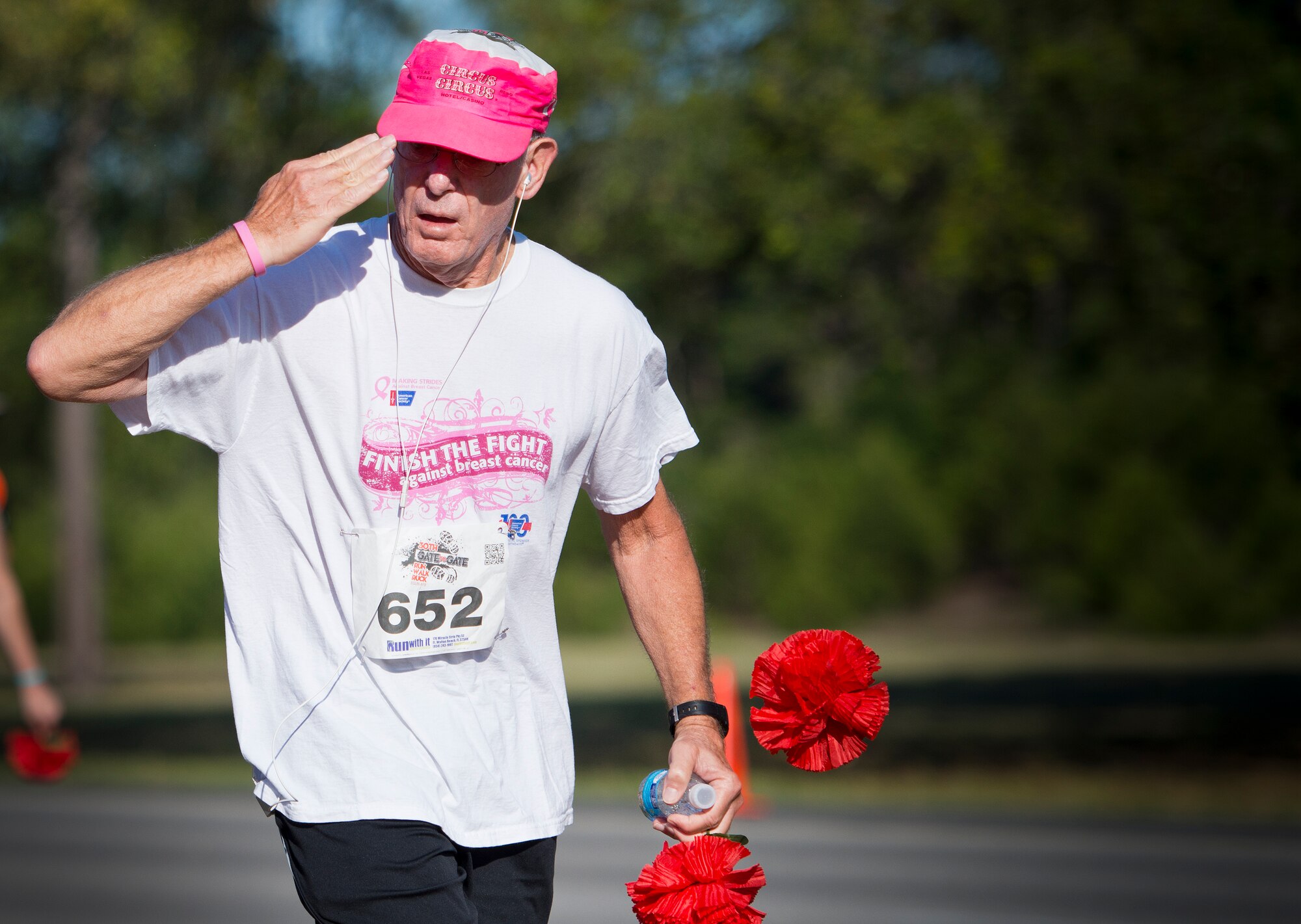 Arthur Rosenbaum, 70, salutes after dropping a red carnation at the All Wars Memorial during the 30th Anniversary Memorial Gate to Gate run May 23 at Eglin Air Force Base, Fla.  More than 1,500 participated in this year’s event.  (U.S. Air Force photo/Samuel King Jr.)