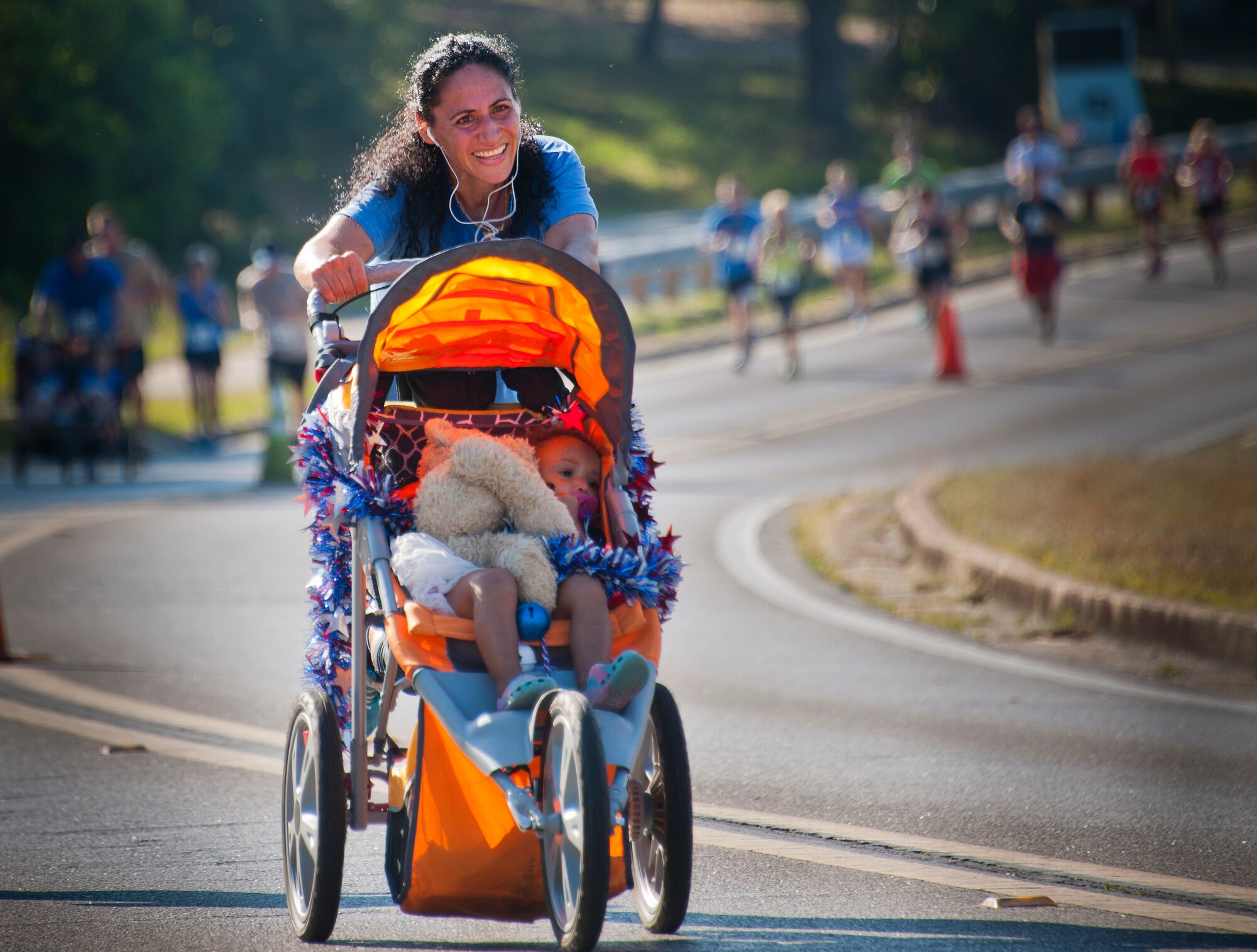 A runner and her child sprint up the final hill toward the finish line during the 30th Anniversary Memorial Gate to Gate run May 23 at Eglin Air Force Base, Fla.  More than 1,500 participated in this year’s event.  (U.S. Air Force photo/Samuel King Jr.)