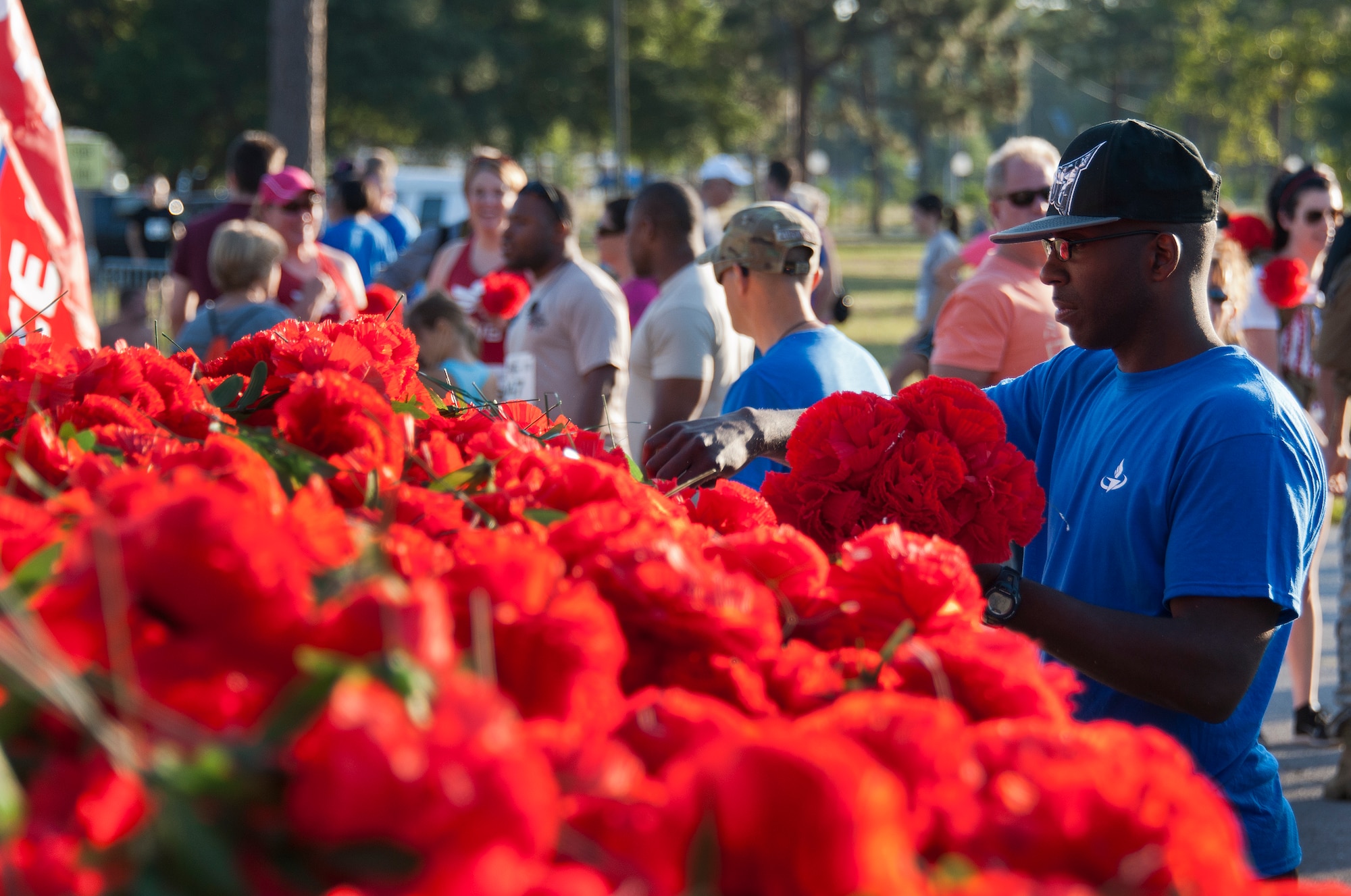 A volunteer gathers carnations to pass out to participants of the 30th Anniversary Memorial Gate to Gate run May 23 at Eglin Air Force Base, Fla.  Runners and walkers dropped off the flowers in front of the All Wars Memorial as they passed by on the race route.  More than 1,500 participated in this year’s event.  (U.S. Air Force photo/Samuel King Jr.)