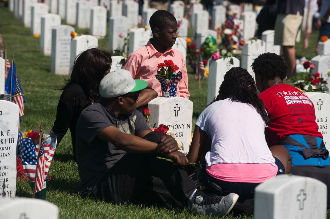 The family of Army Staff Sgt. Anthony Warigi visits his grave on Memorial Day in Section 60 at Arlington National Cemetery in Arlington, Va., May 25, 2015. A family member said Wariti was the second oldest of eight children and he became a father figure to his siblings after the death of their parents. 