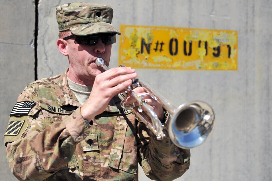 U.S. Army Spc. Smith plays his trumpet during Taps after a Memorial Day