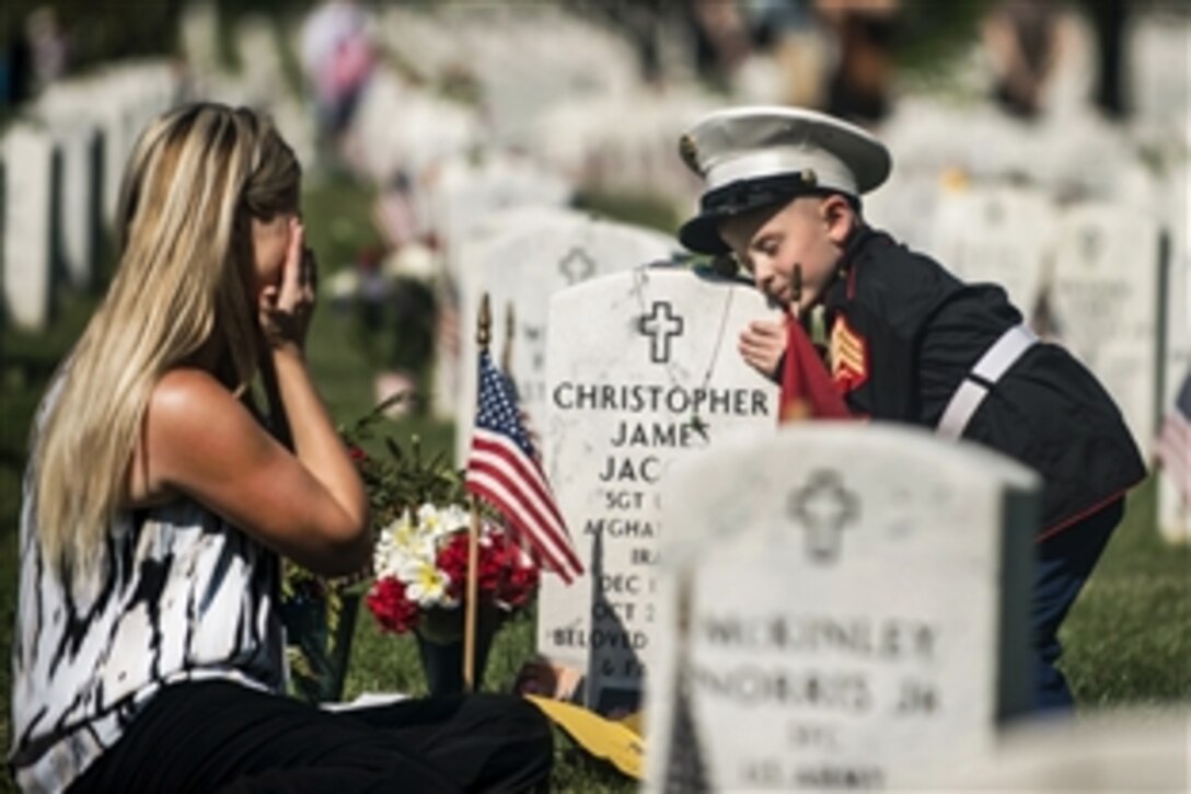 Brittany, left, and her son, Christian, 4, visit the grave of her husband and his father, U.S. Marine Corps Sgt. Christopher Jacobs, on Memorial Day in Section 60 at Arlington National Cemetery in Arlington, Va., May 25, 2015. Christian is wearing his father’s cover.