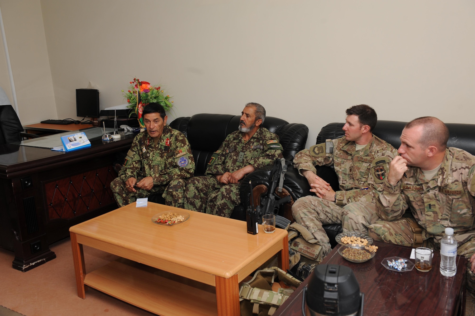 Maj. Sean Stapler and 1st Lt. Steven Braddick, Train, Advise, Assist Command – Air engineer advisers, speak with their Afghan counterparts during a meeting at Kandahar Air Wing, April 29, 2015. (U.S. Air Force photo/Capt. Jeff M. Nagan)