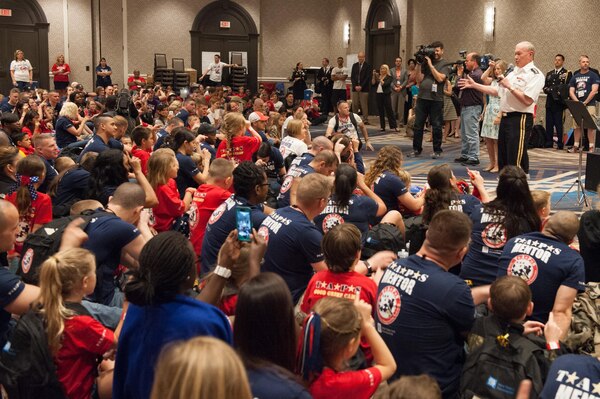 18th Chairman of the Joint Chiefs of Staff Gen. Martin E. Dempsey sings to surviving children at the 21st annual T.A.P.S. National Military Survivor Seminar and Good Grief Camp for Young Survivors, in Arlington, Va., May 22, 2015. Gen. Dempsey addressed surviving family members of fallen service members from both behind a podium and behind a microphone as he sang a few songs.