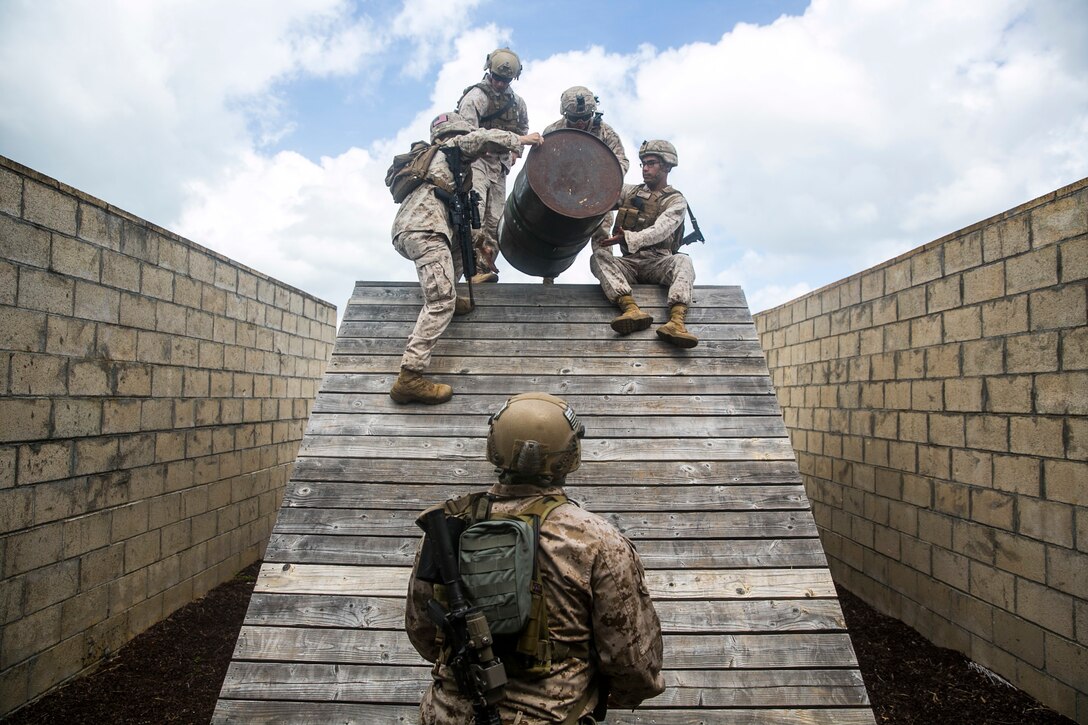 U.S. Marines with the 15th Marine Expeditionary Unit’s Maritime Raid Force participate in a leadership reaction course aboard Marine Corps Base Hawaii, May 18, 2015. In this obstacle, the Marines had to get all personnel, gear, equipment, and the barrel over the bridge without letting the barrel touch the wood. This course is designed to make sure everyone can work as a leader and work with a team. (U.S. Marine Corps photo by Cpl. Anna Albrecht/Released)