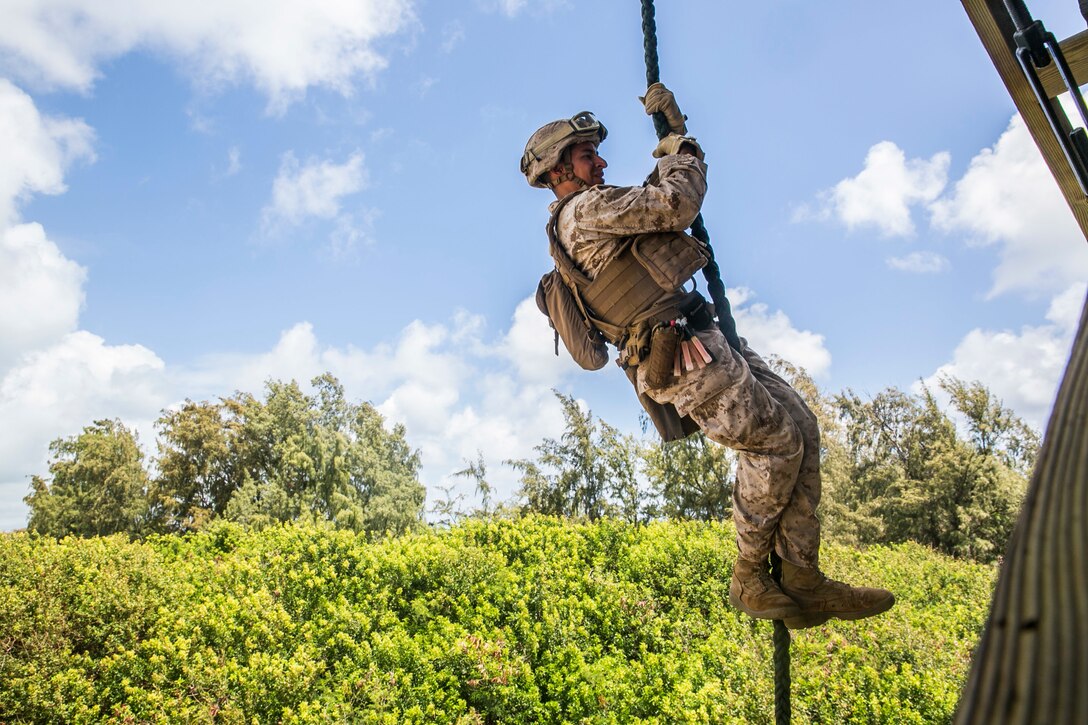 U.S. Marine Lance Cpl. Jose Cortez fast ropes from a tower aboard Marine Corps Base Hawaii, May 12, 2015. Cortez is part of the security element with the 15th Marine Expeditionary Unit’s Maritime Raid Force. These Marines practice fast roping to ensure they are prepared for any type of mission during deployment. (U.S. Marine Corps photo by Cpl. Anna Albrecht/Released)
