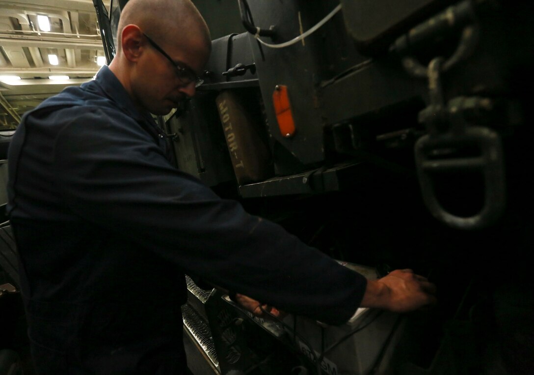 U.S. Marine Cpl. Benjamin E. Tingle charges a dead battery with a pulse charger for a Medium Tactical Vehicle Replacement (MTVR) aboard the USS Anchorage (LPD-23) at sea in the Pacific Ocean, May 15, 2015. Tingle is a motor transportation mechanic with Combat Logistics Battalion, 15th Marine Expeditionary Unit. The Marines and Sailors of the 15th MEU constantly perform maintenance on their equipment to maintain combat readiness. (U.S. Marine Corps photo by Cpl. Steve H. Lopez/Released)