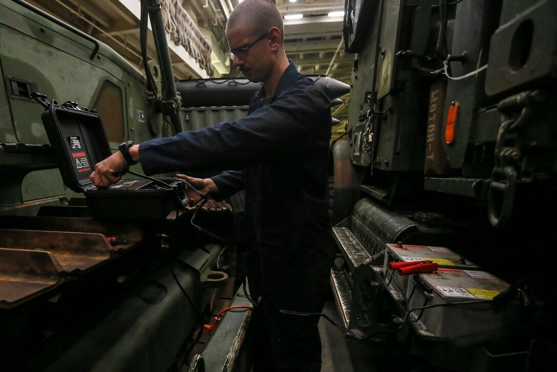 U.S. Marine Cpl. Benjamin E. Tingle charges a dead battery with a pulse charger for a Medium Tactical Vehicle Replacement (MTVR) aboard the USS Anchorage (LPD-23) at sea in the Pacific Ocean, May 15, 2015. Tingle is a motor transportation mechanic with Combat Logistics Battalion, 15th Marine Expeditionary Unit. The Marines and Sailors of the 15th MEU constantly perform maintenance on their equipment to maintain combat readiness. (U.S. Marine Corps photo by Cpl. Steve H. Lopez/Released)