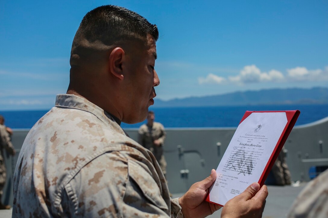 U.S. Marine 1st Sgt. Arturo Cisneros reads the promotion warrant during Sgt. Jose A. Lopez’s promotion ceremony aboard the USS Anchorage (LPD 23) at sea in the Pacific Ocean, May 21, 2015. Cisneros is the company 1st Sgt for Headquarters and Service Company, Battalion Landing Team 3rd Battalion, 1st Marine Regiment, 15th Marine Expeditionary Unit. (U.S. Marine Corps photo by Cpl. Steve H. Lopez/Released