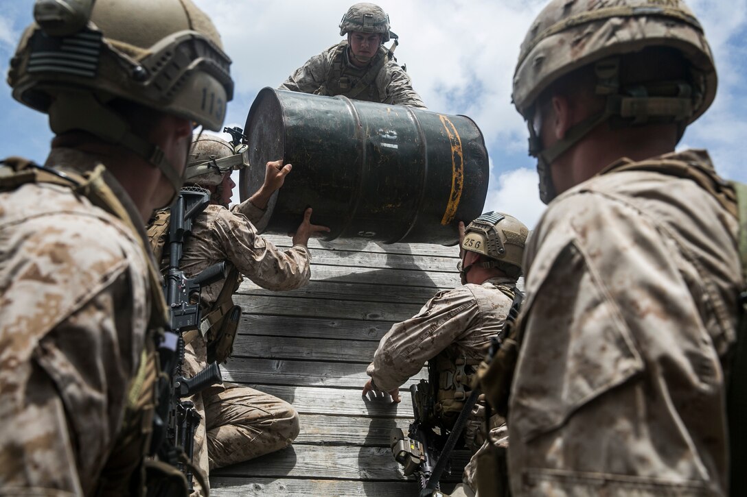 U.S. Marines with the 15th Marine Expeditionary Unit’s Maritime Raid Force work together to complete an obstacle at a leadership reaction course aboard Marine Corps Base Hawaii, May 18, 2015. At the LRC, the Marines were split into random teams, consisting of both Force Reconnaissance Marines and security element Marines, challenging them to work together in groups they are unfamiliar with. The course is designed to challenge the Marines leadership capabilities by solving obstacles with limited time and equipment. (U.S. Marine Corps photo by Cpl. Anna Albrecht/Released)