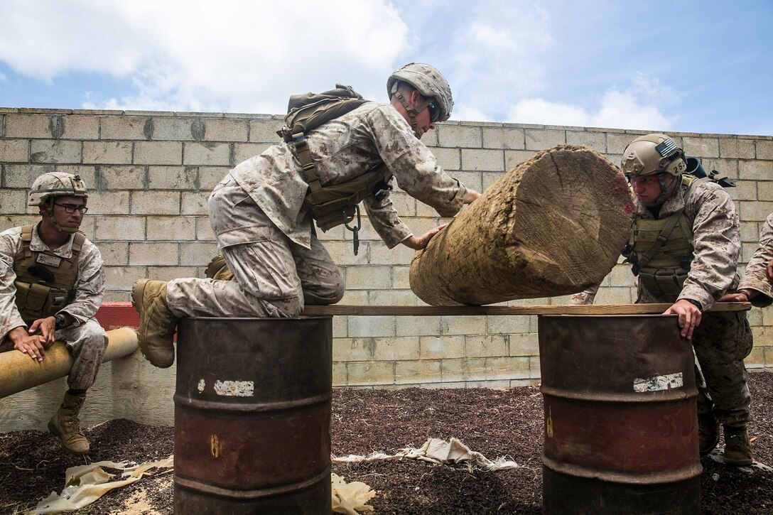 U.S. Marines with the 15th Marine Expeditionary Unit’s Maritime Raid Force work together to complete an obstacle of the leadership reaction course aboard Marine Corps Base Hawaii, May 18, 2015. At the LRC, the Marines were split into random teams, consisting of both Force Reconnaissance Marines and security element Marines, challenging them to work together in groups they are unfamiliar with. (U.S. Marine Corps photo by Cpl. Anna Albrecht/Released)