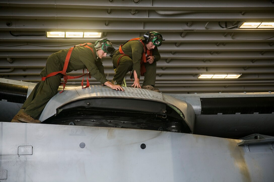 U.S. Marine Lance Cpl. Nathan Baungartner, left, and Staff Sgt. Wayne Makinen work on an MV-22B Osprey in the hangar bay of the USS Essex (LHD 2), at sea in the Pacific Ocean, May 21, 2015. Baungartner and Makinen are avionic technicians with Marine Medium Tiltrotor Squadron 161 (Reinforced), 15th Marine Expeditionary Unit. They work on their aircraft daily to ensure they are always mission ready. (U.S. Marine Corps photo by Cpl. Anna Albrecht/Released)