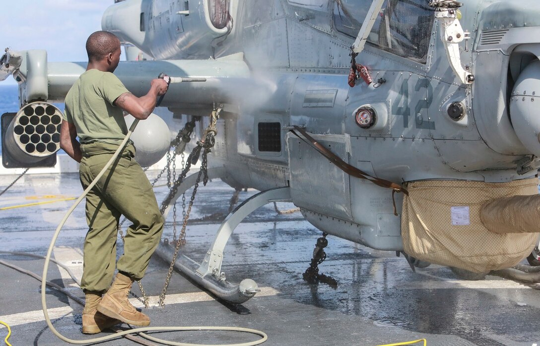 U.S. Marine Lance Cpl. Zion Song rinses an AH-1Z Viper aboard the USS Anchorage (LPD-23) at sea in the Pacific Ocean, May 17, 2015. Song is an airframe mechanic with Marine Medium Tiltrotor Squadron 161 (Reinforced), 15th Marine Expeditionary Unit. The Marines of the 15th MEU’s aviation combat element keep their aircraft clean and ready for combat. (U.S. Marine Corps photo by Cpl. Steve H. Lopez/Released)