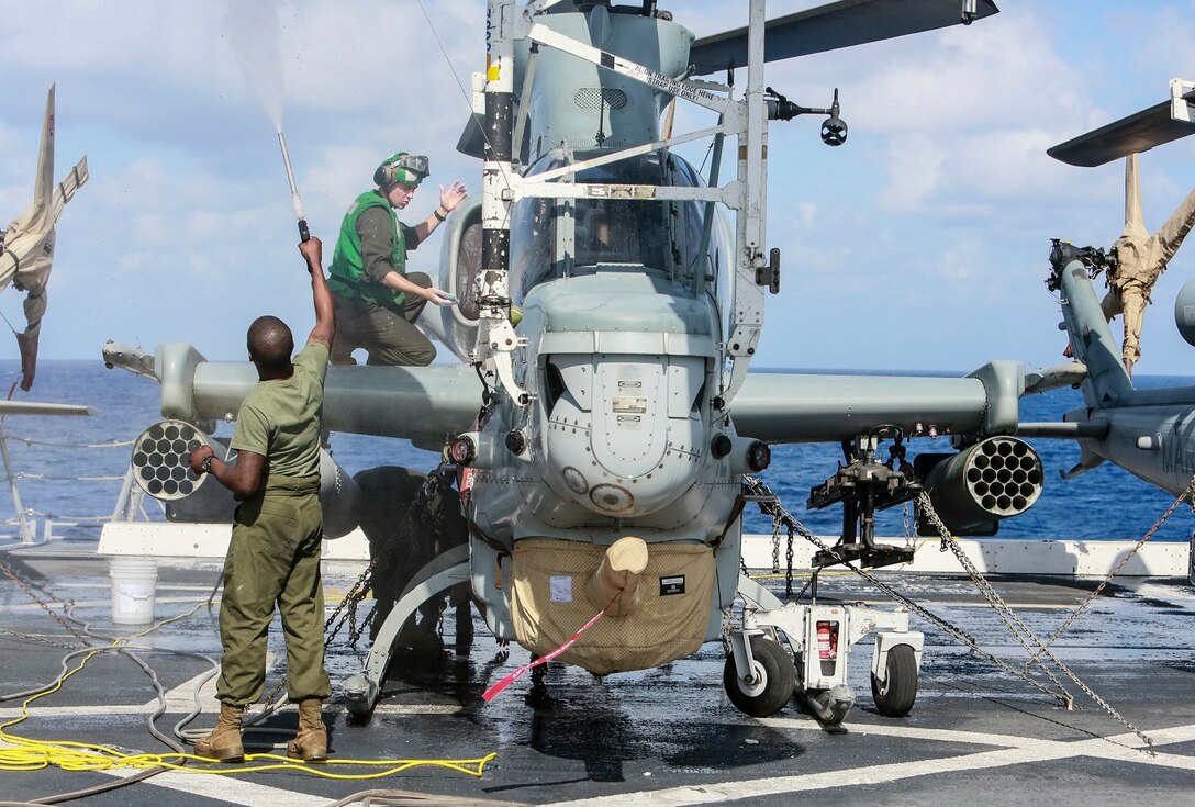 U.S. Marine Cpl. Jared Odom, right, scrubs the side of an AH-1Z Viper while Lance Cpl. Zion Song rinses the aircraft aboard the USS Anchorage (LPD-23) at sea in the Pacific Ocean, May 17, 2015. Both Odom and Song are airframe mechanics with Marine Medium Tiltrotor Squadron 161 (Reinforced), 15th Marine Expeditionary Unit. The Marines of the 15th MEU’s aviation combat element keep their aircraft clean and ready for combat. (U.S. Marine Corps photo by Cpl. Steve H. Lopez/Released)