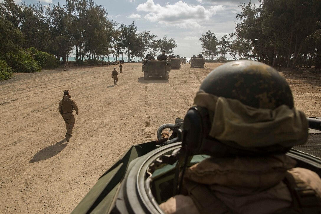 U.S. Marine Lance Cpl. Jose Martinez, left, guides Cpl. Christopher Jimerson during amphibious troop transport training aboard Marine Corps Base Hawaii, May 19, 2015. Martinez is an amphibious assault crewman, and Jimerson is a crew chief with with Kilo Company, Battalion Landing Team 3rd Battalion, 1st Marine Regiment, 15th Marine Expeditionary Unit. During the training, Marines rehearsed amphibious troop transport using AAV-7 Amphibious Assault Vehicles. (U.S. Marine Corps photo by Sgt. Emmanuel Ramos/Released)