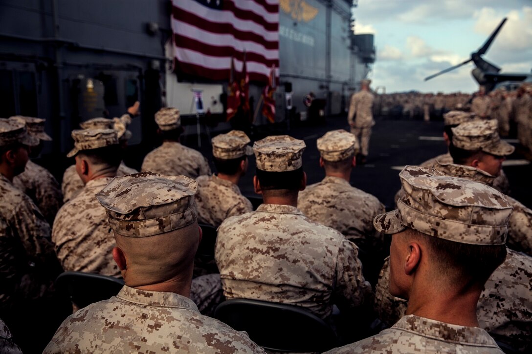 U.S. Marines with the 15th Marine Expeditionary Unit attend the memorial service in honor of Cpl. Joshua Barron and Lance Cpl. Matthew Determan aboard the flight deck of the USS Essex (LHD 2) at sea in the Pacific Ocean, May 23, 2015. Marines and Sailors with the 15th MEU and the Essex Amphibious Ready Group paused during deployment to pay their respects and honor the two Marines. (U.S. Marine Corps photo by Cpl. Elize McKelvey/Released)