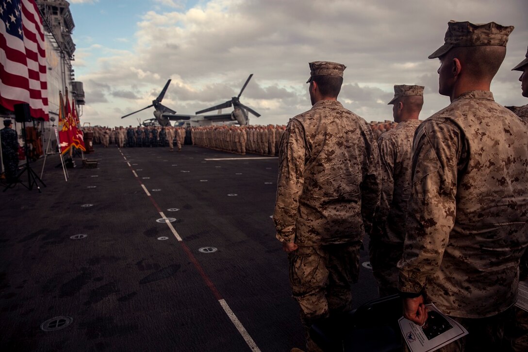 U.S. Marines with the 15th Marine Expeditionary Unit stand in formation during the memorial of Cpl. Joshua Barron and Lance Cpl. Matthew Determan aboard the flight deck of the USS Essex (LHD 2) at sea in the Pacific Ocean, May 23, 2015. Marines and Sailors with the 15th MEU and the Essex Amphibious Ready Group paused during deployment to pay their respects and honor the two Marines. (U.S. Marine Corps photo by Cpl. Elize McKelvey/Released)