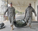 Army Spcs. Adam Schroeder (left) and Bernard Satchell, both with the Georgia National Guard’s 124th Mobile Public Affairs Detachment, preposition the unit’s tents to house unit members should they be called out to assist during the storm expected to hit Georgia today.