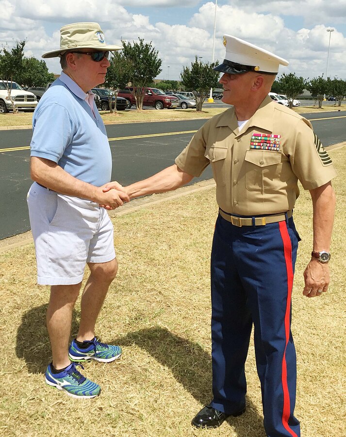 Sgt. Maj. Joseph Davenport, sergeant major, Marine Corps Logistics Command, shakes hands with a participant following the Field of Crosses Memorial Day ceremony held in front of the Albany Mall, May 24. After giving a brief history of Memorial Day during the ceremony, Davenport told those gathered that Memorial Day is the ultimate American holiday often confused with Veterans Day. "It is a day often used by retail establishments as a sales day; by sports fans for races such as the Indy 500 and Coca-Cola 600 and so on. But if you ask a veteran or a family member, they will tell you it represents something else. John 15:15 says, ‘Greater love hath no man than this, that a man lay down his life for his friends.’ So tomorrow at 3 p.m., please pause for a national moment of remembrance to honor that fallen warrior for his or her sacrifice," he said.