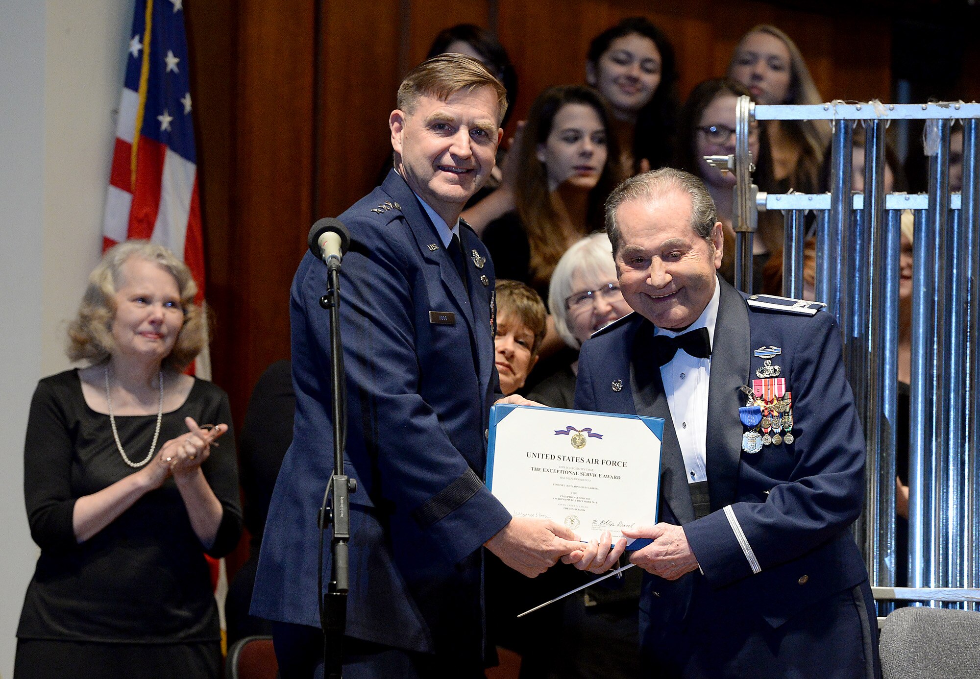 Air Force Assistant Vice Chief of Staff Gen. Stephen Hoog pins the Exceptional Service Medal on the coat of retired Col. Arnald Gabriel, after he conducted a special Memorial Day concert performance by the by Air Force Symphony at the John F. Kennedy Center for the Performing Arts May 24, 2015, in Washington, D.C. Gabriel served in the Army as a combat machine gunner and landed in Normandy, France, on D-Day with the 29th Infantry Division.  He later became an Air Force officer and served with the U.S. Air Force Band.  Gabriel retired as the band's commander in 1985. (U.S. Air Force photo/Scott M. Ash)