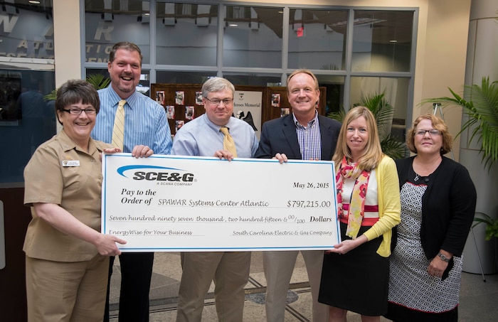 Navy Capt. Amy Burin, commanding officer of Space and Naval Warfare (SPAWAR) Systems Center (SSC) Atlantic, along with Executive Director Steve Dunn, Facilities Manager Darrell Denaux and Energy Program Manager Tom Egbert accept a rebate check from South Carolina Electric and Gas (SCE&G) in the amount of $797,215 May 26 at the Naval Weapons Station - Joint Base Charleston. The check is a result of successful energy savings rebate initiatives under SSC Atlantic’s Energy Savings Performance Contract (ESPC)through Huntsville Center and SCE&G’s EnergyWise for your Business program. 