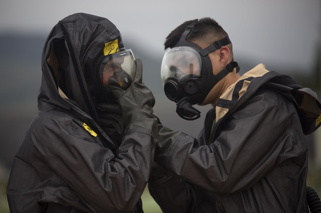 Two chemical, biological, radiological, nuclear defense specialists  ensure gas masks are properly fitted prior to leak, seal, package and decontamination training April 21 at the gas chamber on Camp Hansen, Okinawa. The CBRN defense specialists assisted in familiarizing explosive ordnance disposal technicians with decontamination procedures following the leak, seal, package process used to mitigate CBRN-related hazards.  The EOD technicians and CBRN defense specialists used protective equipment to perform general decontamination of the affected area and prepare the leaking ordnance for safe containment and transport before completing the decontamination process. The training instilled the Marines’ confidence in their safety equipment and procedures used to mitigate CBRN-related hazards. The Marines are with 9th Engineer Support Battalion, and Marine Logistics Group Headquarters Regiment, 3rd MLG, III Marine Expeditionary Force. 