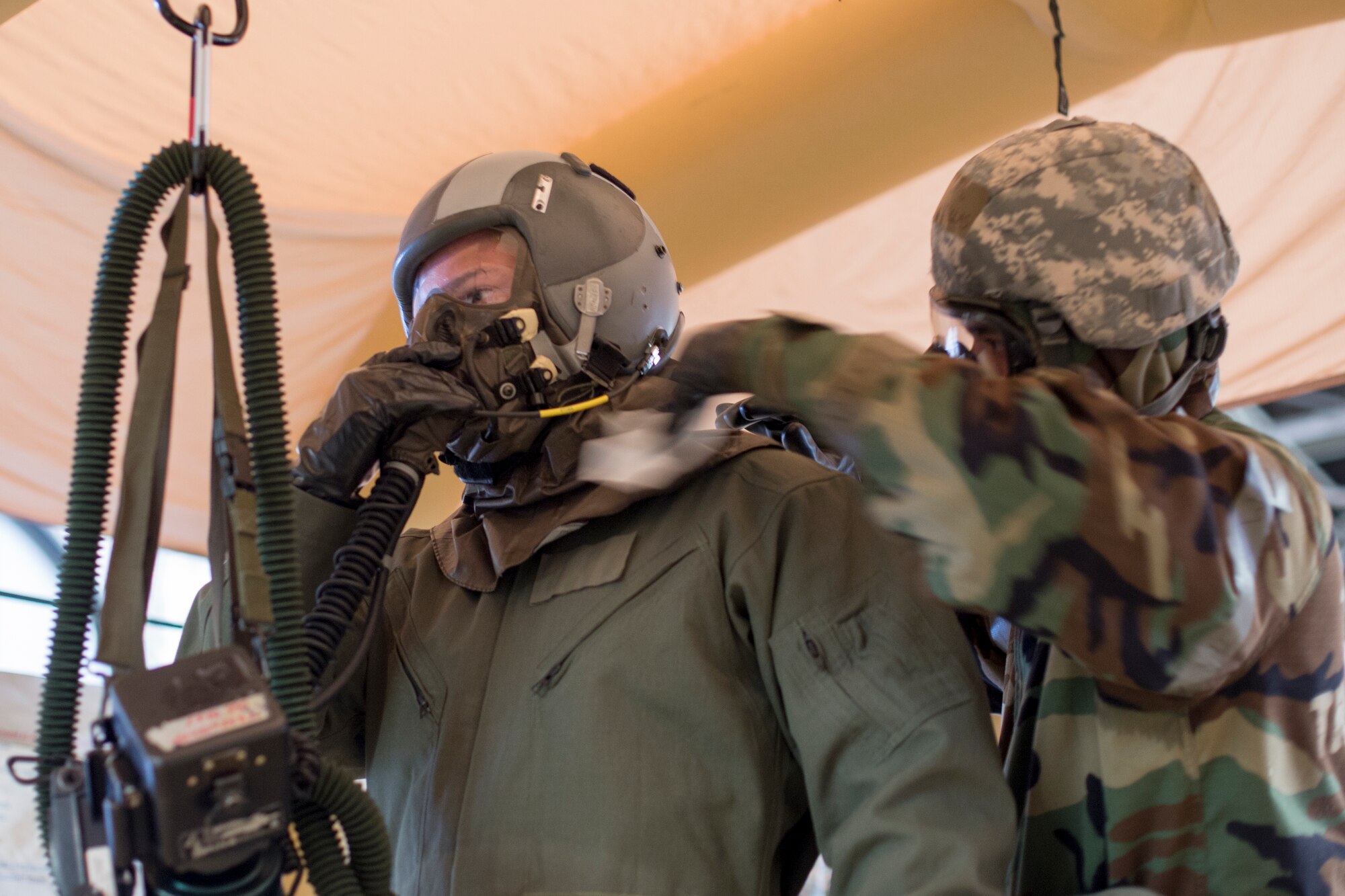 Senior Airman Kenny Batallas, 374th Operations Support Squadron aircrew flight equipment, right, wipes an aircrew member’s simulated potentially contaminated equipment during a Samurai Readiness Inspection at Yokota Air Base, Japan, May 20, 2015. Airmen from the 36th Airlift Squadron and 374th OSS performed aircrew decontamination procedures with the Lightweight Inflatable Decontamination System (LIDS). The LIDS takes about 20 minutes to set up and consists of four stations for rinsing off excess chemicals and a process to dispose of contaminated clothing and aircrew equipment. (U.S. Air Force photo by Osakabe Yasuo/Released)