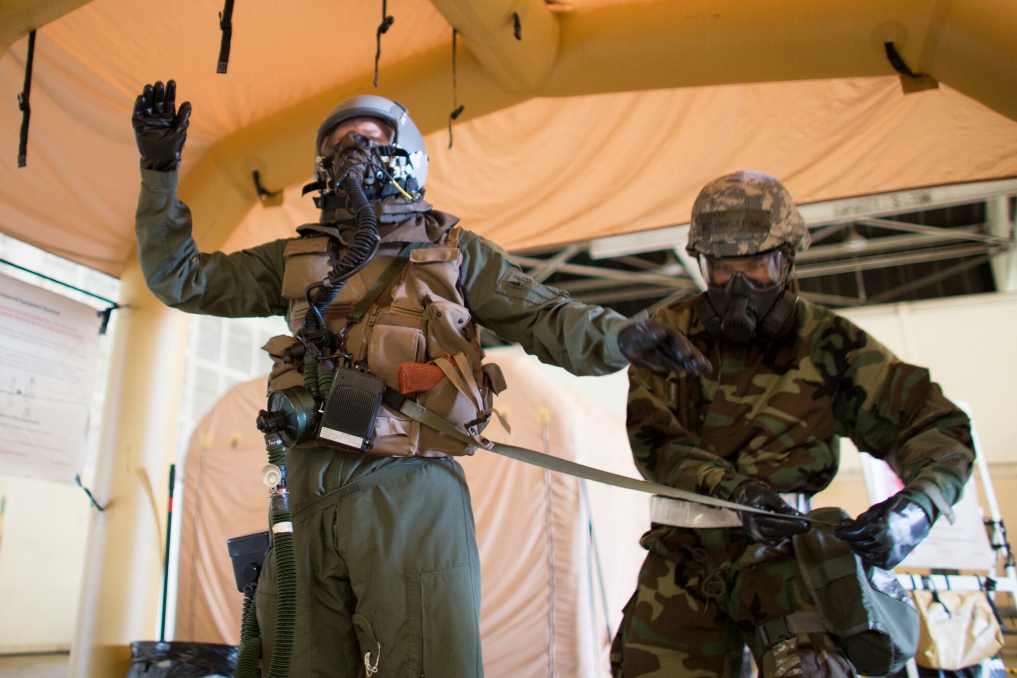 Airman 1st Class Ronald Flanagan, 374th Operations Support Squadron aircrew flight equipment, removes simulated potentially contaminated equipment during a Samurai Readiness Inspection at Yokota Air Base, Japan, May 20, 2015. Airmen from the 36th Airlift Squadron and 374th OSS performed aircrew decontamination procedures with the Lightweight Inflatable Decontamination System (LIDS). The LIDS takes about 20 minutes to set up and consists of four stations for rinsing off excess chemicals and a process to dispose of contaminated clothing and aircrew equipment. (U.S. Air Force photo by Osakabe Yasuo/Released)