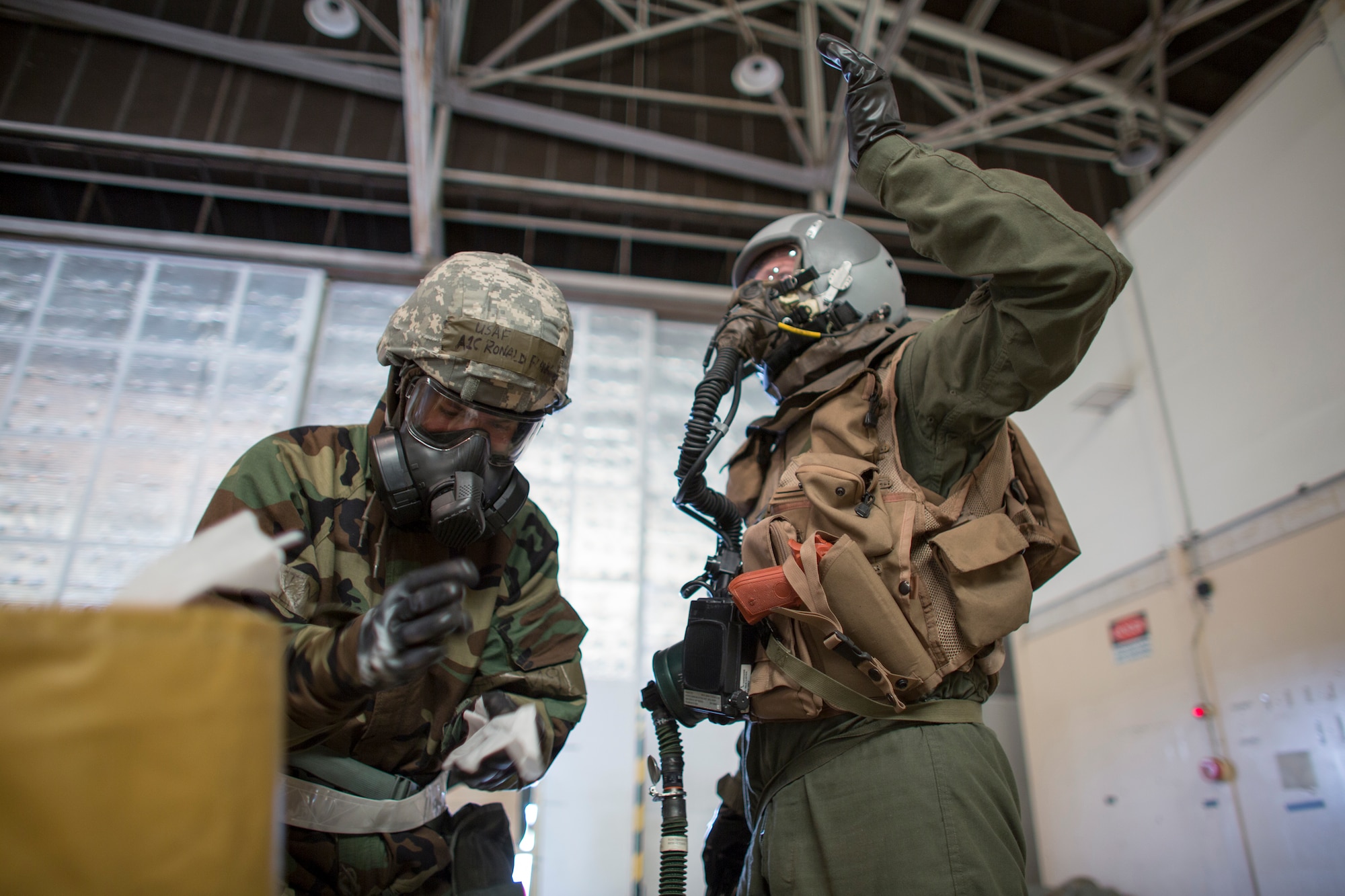 Airman 1st Class Ronald Flanagan, 374th Operations Support Squadron aircrew flight equipment, wipes his hands after checking simulated contaminated equipment at Yokota Air Base, Japan, May 20, 2015, during a Samurai Readiness Inspection. Airmen from the 36th Airlift Squadron and 374th OSS performed aircrew decontamination procedures with the Lightweight Inflatable Decontamination System (LIDS). The LIDS takes about 20 minutes to set up and consists of four stations for rinsing off excess chemicals and a process to dispose of contaminated clothing and aircrew equipment. (U.S. Air Force photo by Osakabe Yasuo/Released)