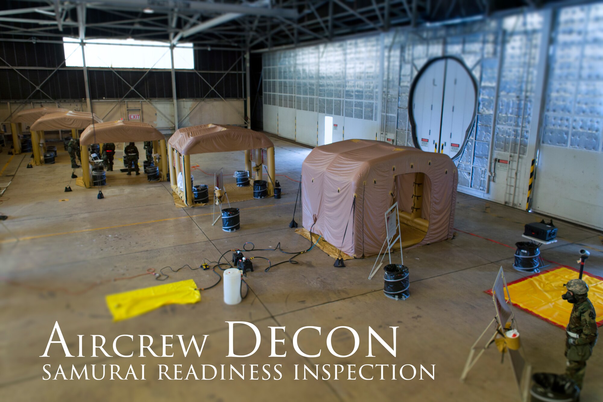 Airmen from the 374th Operations Support Squadron aircrew flight equipment shop, set up an aircrew decontamination system at Yokota Air Base, Japan, May 20, 2015, during a Samurai Readiness Inspection. The Lightweight Inflatable Decontamination System (LIDS) takes about 20 minutes to set up and consists of four stations for rinsing off excess chemicals and a process to dispose of contaminated clothing and aircrew equipment. (U.S. Air Force photo illustration by Osakabe Yasuo/Released)