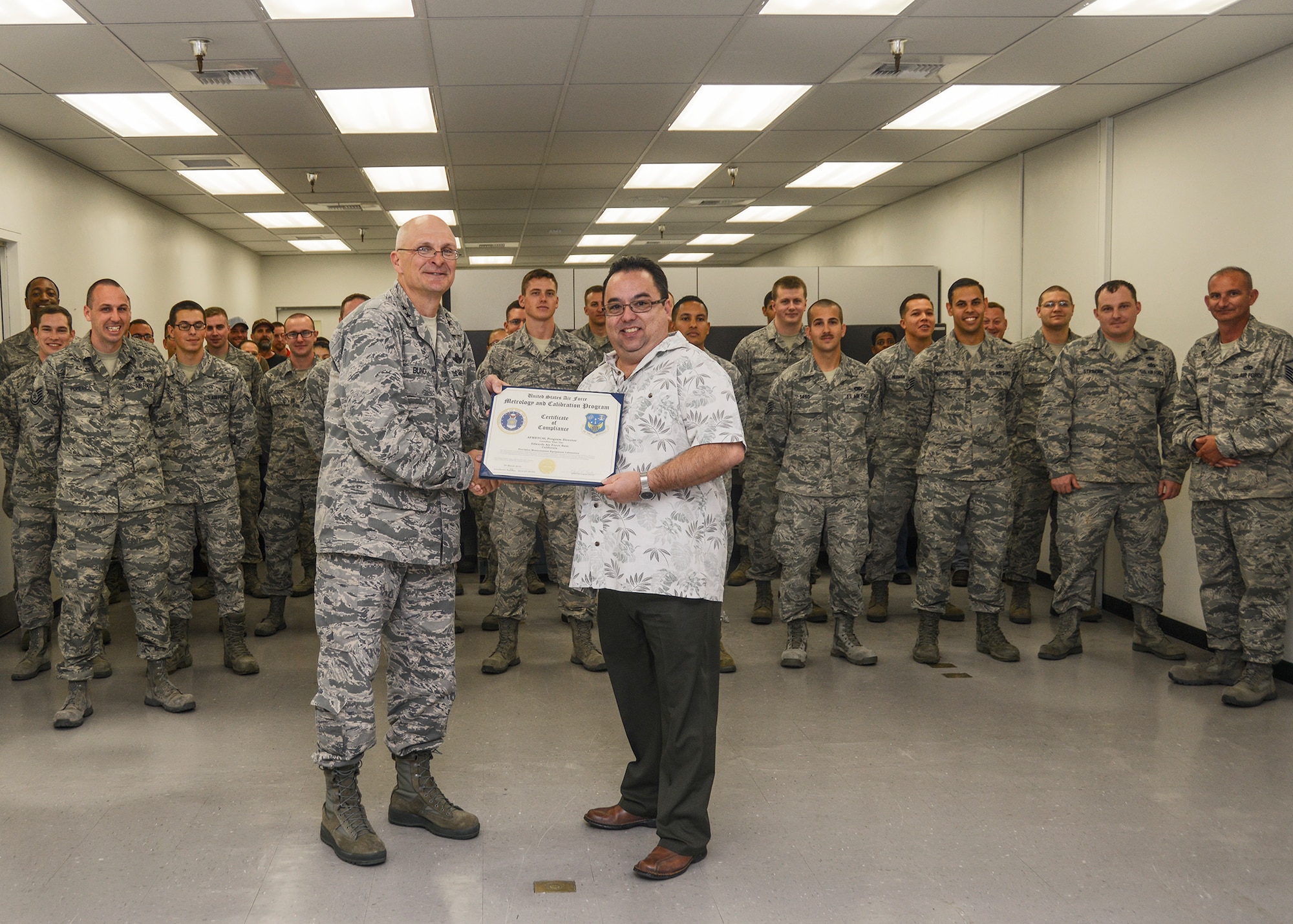 Maj. Gen. Arnold Bunch Jr., Air Force Test Center commander, presents the biannual Air Force Metrology and Calibration Laboratory Evaluation certificate to Daniel Tibayan, Test Measurement and Diagnostic Equipment Flight chief, and the rest of the Precision Measuring Equipment Laboratory May 21. (U.S. Air Force photo by Rebecca Amber)