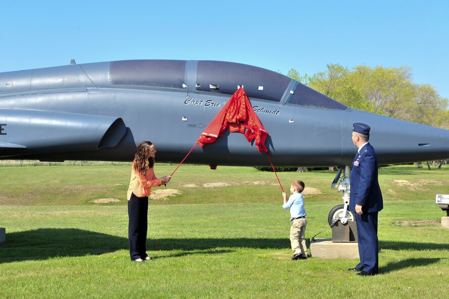 Capt. Eric Schmidt’s family reveals his name on a T-38 Talon during a dedication ceremony on Minot Air Force Base, May 21, 2015. The aircraft was dedicated to Schmidt because of his love for aircraft, his love of flying and his diligence to take care of those around him. (U.S. Air Force photo/Senior Airman Malia Jenkins) 