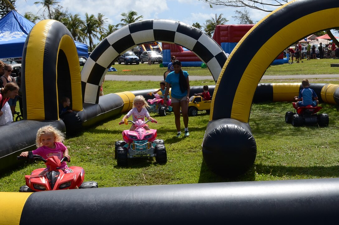 Children race around an inflatable race track at the Memorial Day Bash May 25, 2015, Andersen Air Force Base, Guam. The event included family friendly activities, such as zip lining, multiple bounce houses, food, a barbeque cook-off and a kids’ race track to entertain Team Andersen during the holiday commemoration. (U.S. Air Force photo by Airman 1st Class Alexa Ann Henderson/Released)
