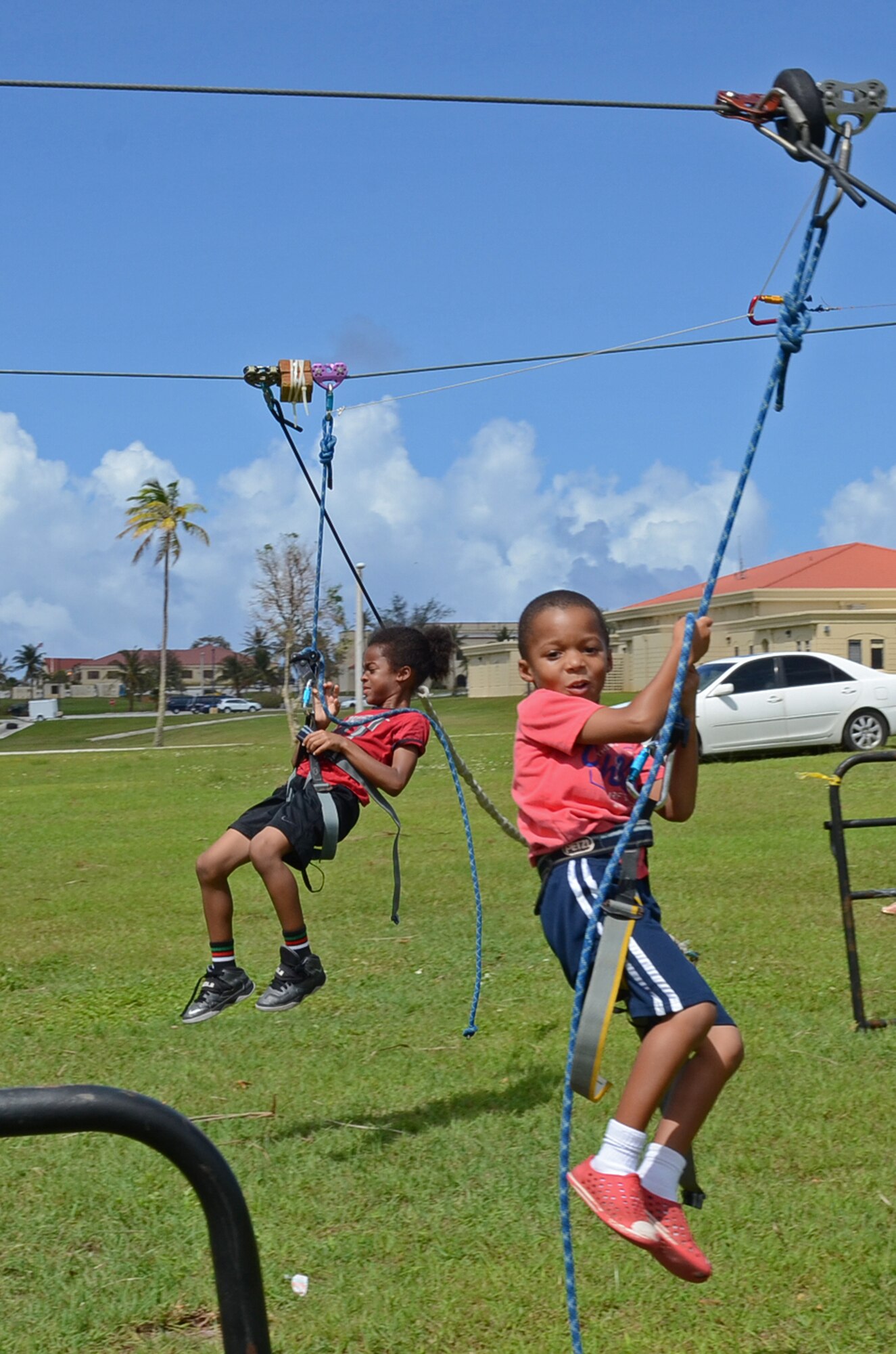 Andersen family members enjoy a ride on a zip line at the Memorial Day Bash May 25, 2015, at Andersen Air Force Base, Guam. The event included family friendly activities, such as zip lining, multiple bounce houses, food, a barbeque cook-off and a kids’ race track to entertain Team Andersen during the holiday commemoration. (U.S. Air Force photo by Airman 1st Class Alexa Ann Henderson/Released)