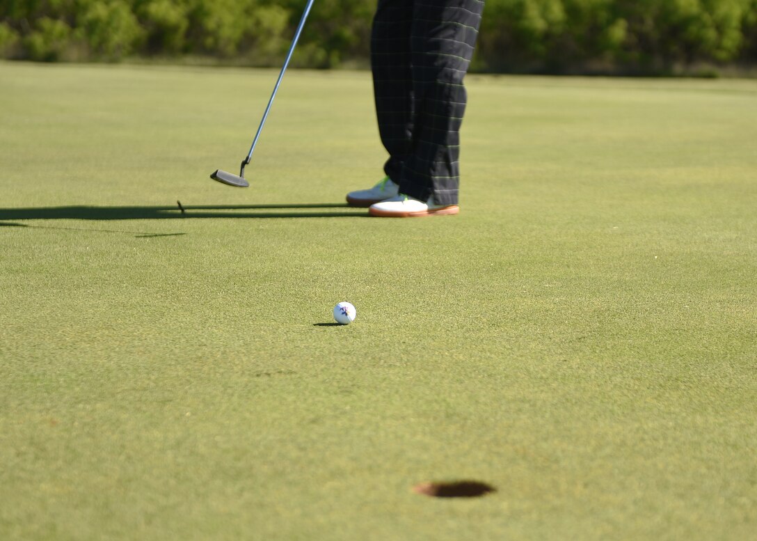 U.S. Air Force Maj. Josh Nassef, 28th Bomb Squadron, putts his golf ball during the B-1B Anniversary Golf Tournament April 30, 2015, at Dyess Air Force Base, Texas. Nassef played the 18-hole course along with other participants to celebrate the 30th anniversary of the first B-1B Lancer delivered to the Air Force. (U.S. Air Force photo by Airman 1st Class Alexander Guerrero/Released)