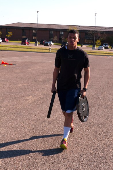 Airman 1st Class Dalvin Jackson, 5th Security Forces Squadron defender, carries weights in the relay portion of the Security Forces Survivors Challenge on Minot Air Force Base, N.D., May 20, 2015. Security forces teams competed against each other for a medal and bragging rights within the squadron. (U.S. Air Force photo/Airman 1st Class Christian Sullivan)