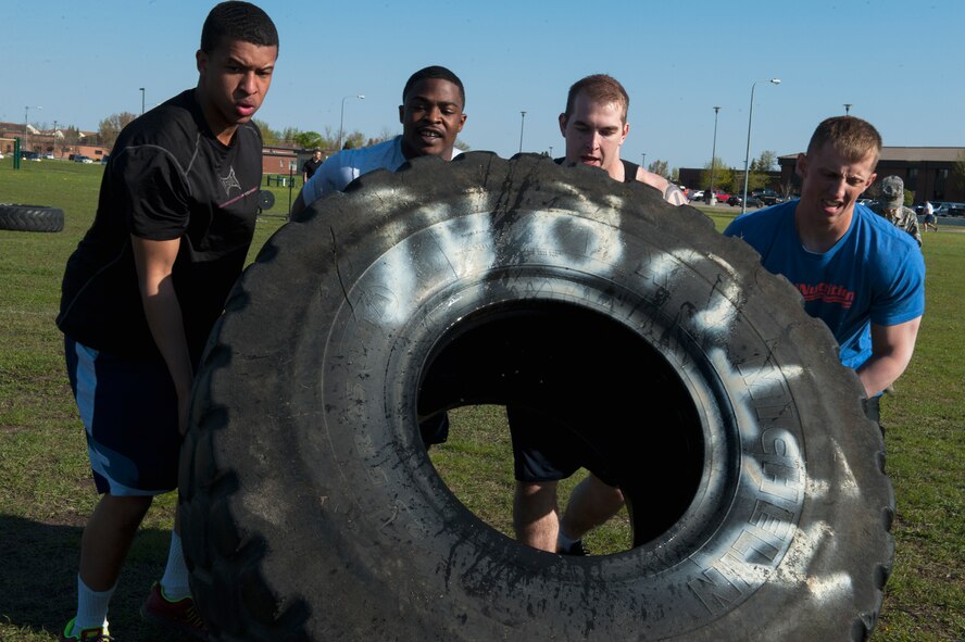 Airmen from the 5th Security Forces Squadron Charlie Flight flip a tire in the Security Forces Survivors Challenge on Minot Air Force Base, N.D., May 20, 2015. Despite a hard fought battle, Charlie Flight came in second place to Bravo Flight. (U.S. Air Force photo/Airman 1st Class Christian Sullivan)